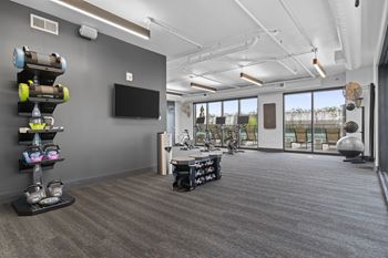room with gym equipment and a television at the district flats apartments at Deca Apartments, Greenville, 29601